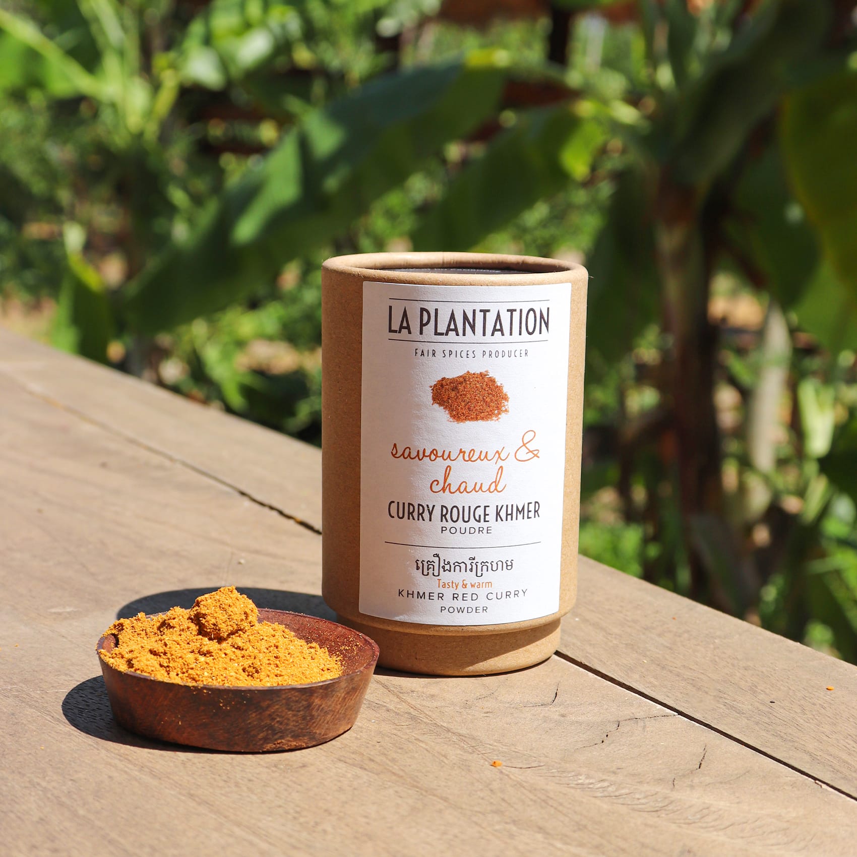 poudre de curry rouge dans un pot sur une surface en bois