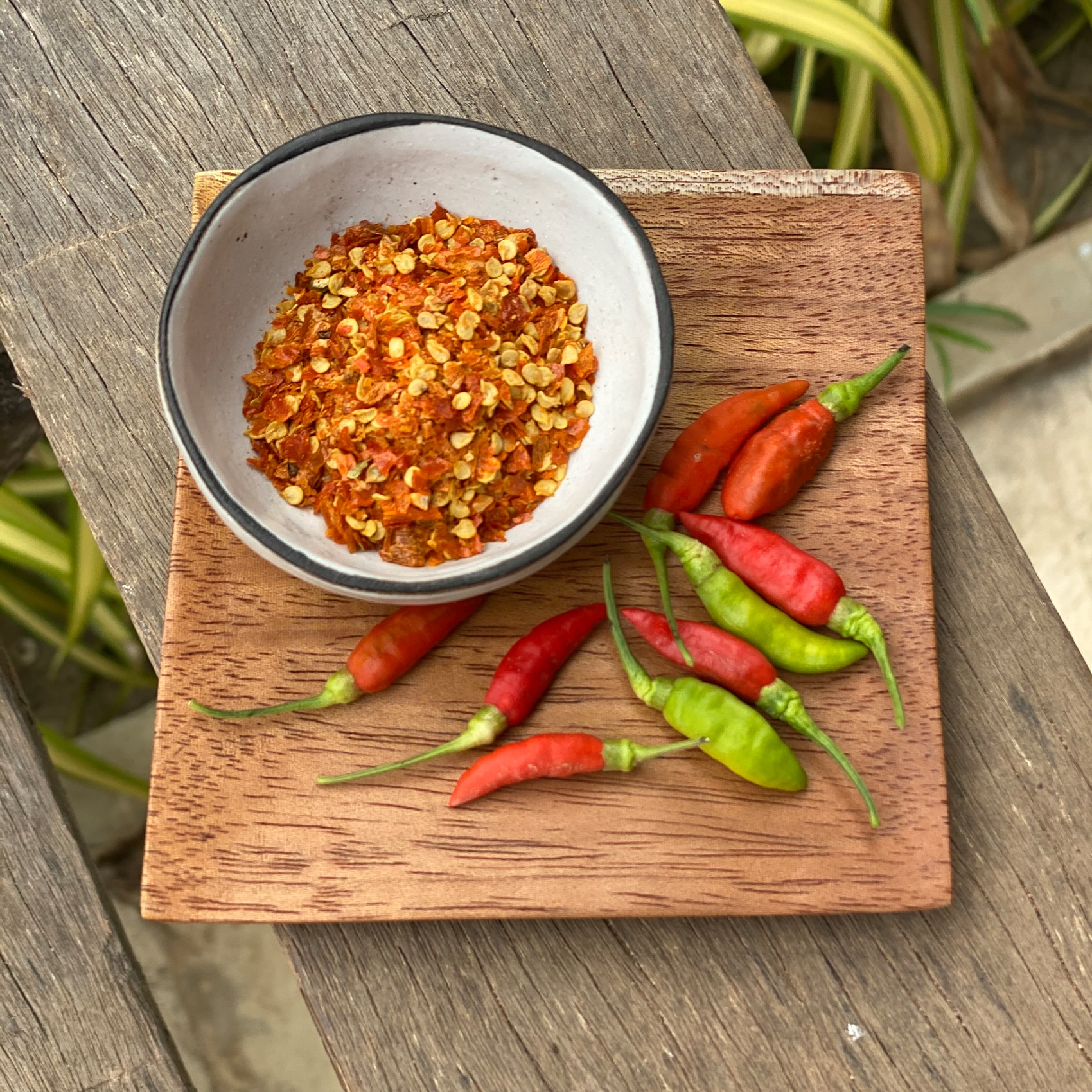 piments concassés et entiers sur une planche en bois