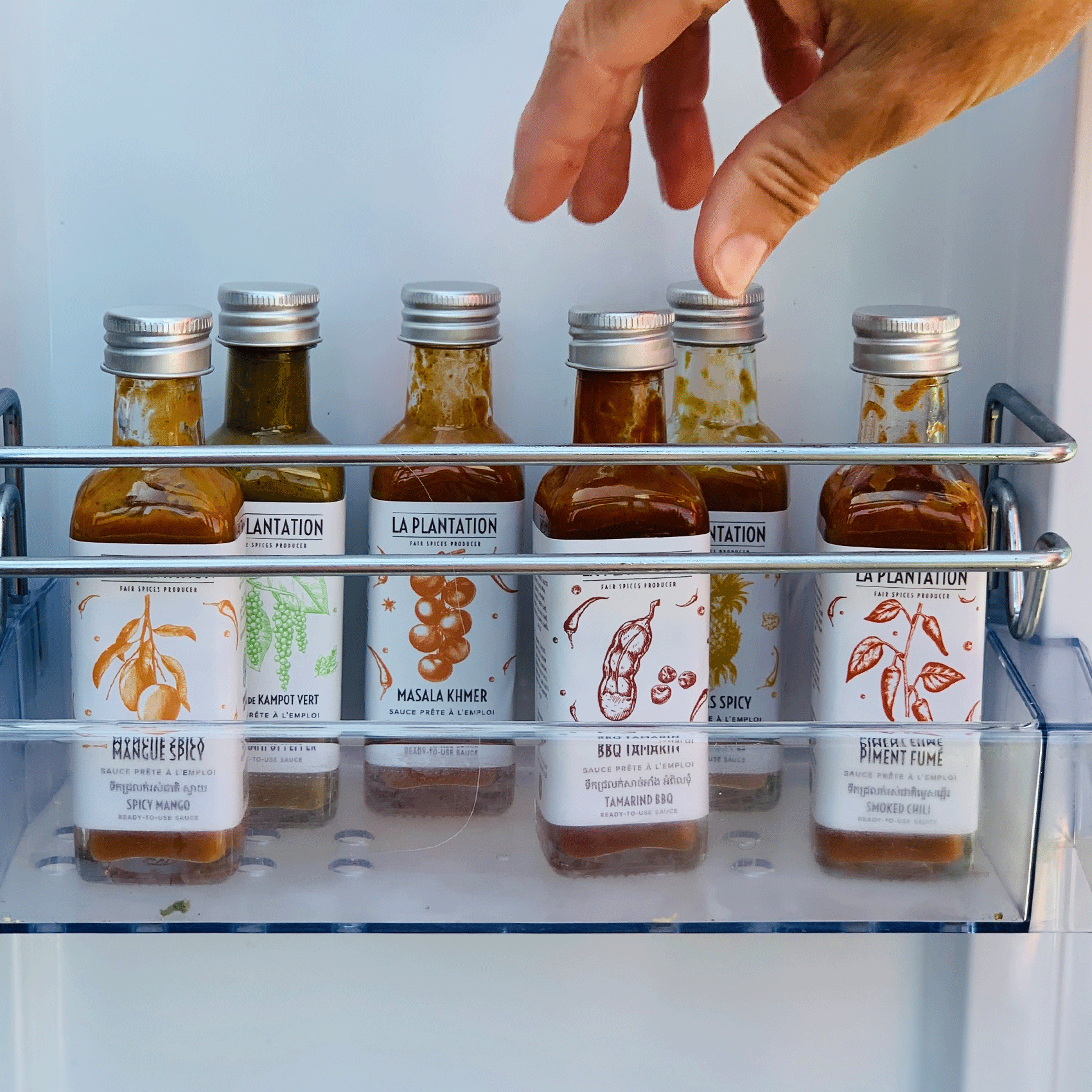 Flaschen mit scharfen Soßen, die im Kühlschrank aufbewahrt werden