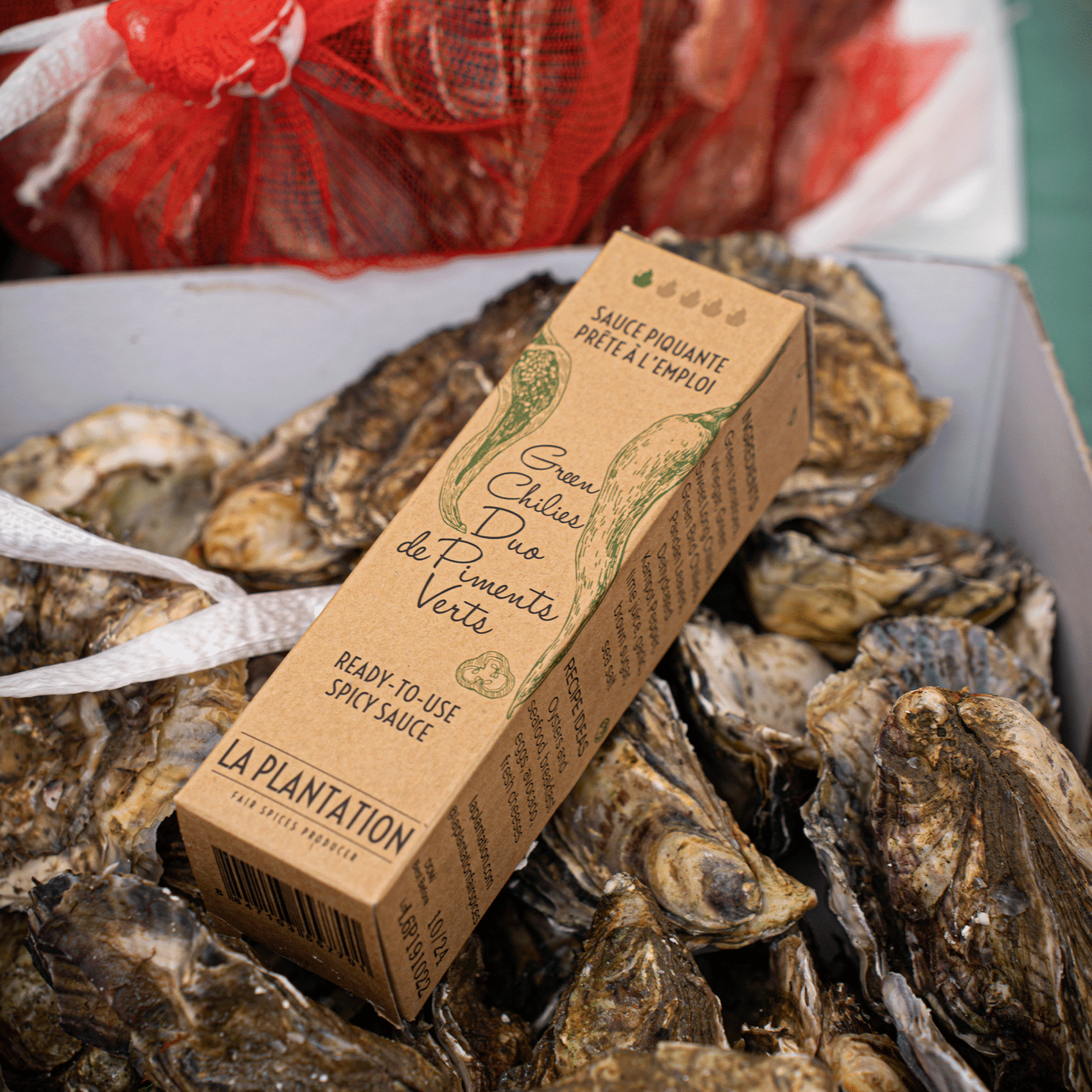 Dose mit grüner Chilisauce und gestapelten Austern