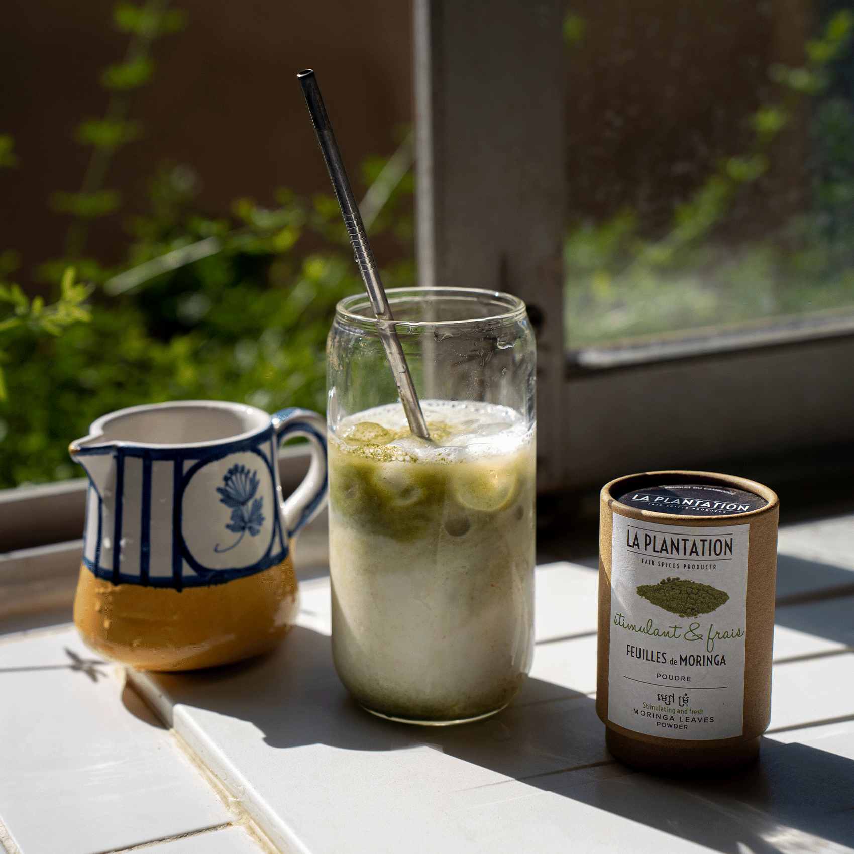 moringa latte et tasse sur une surface en carrelage