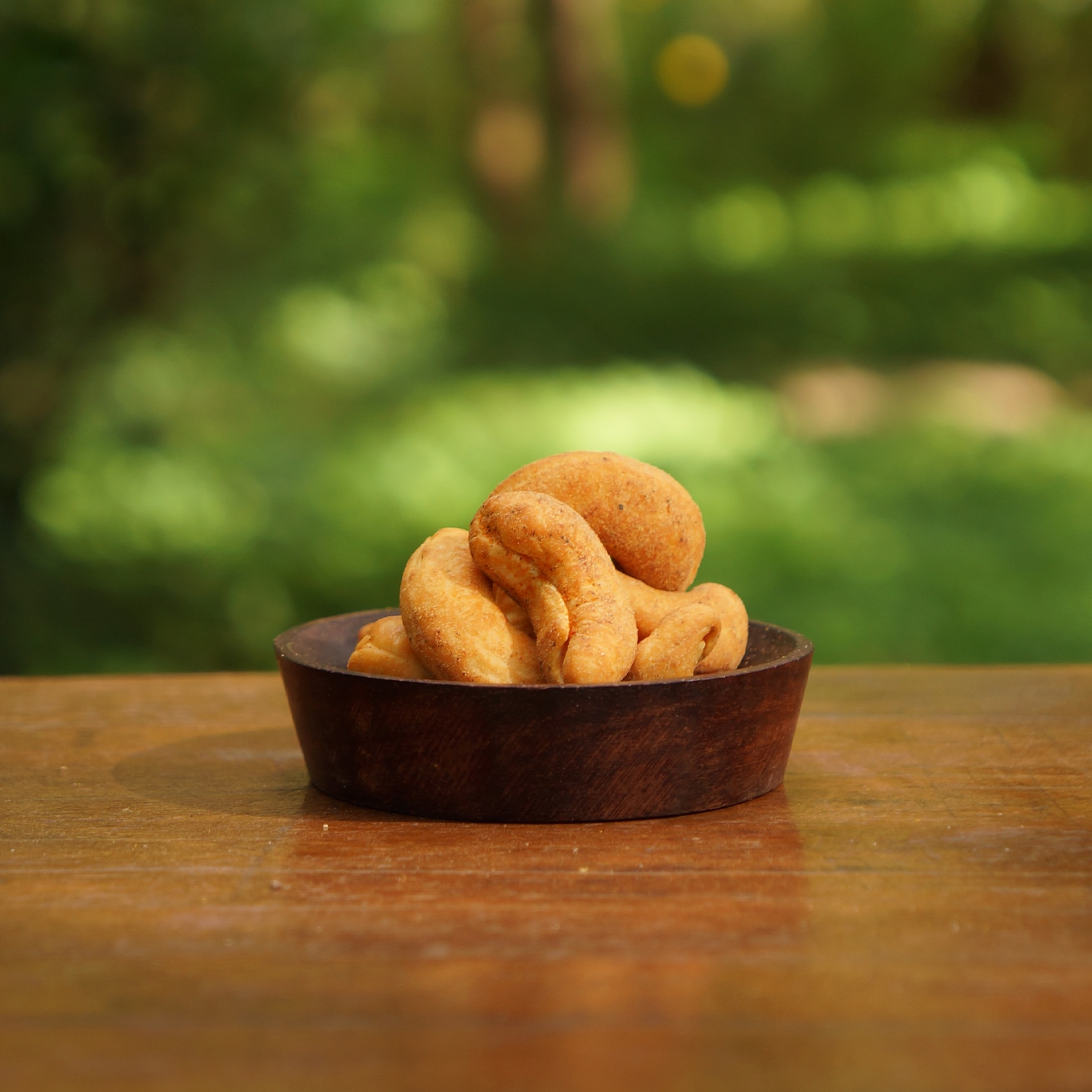 noix de cajou fumées dans un bol sur une table en bois
