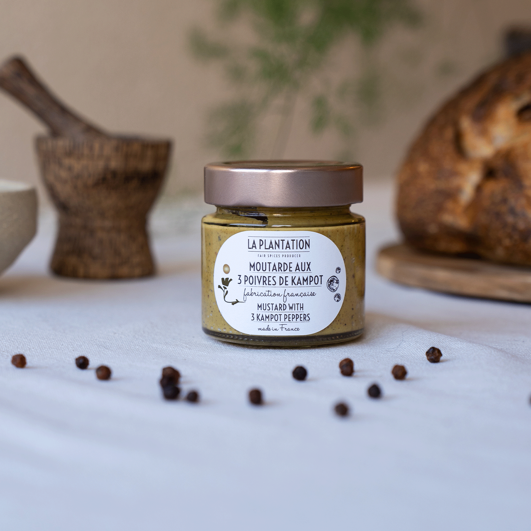 pot de moutarde et grains de poivre sur une nappe