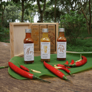 bouteilles de sauces piquantes et piments rouges sur une surface en bois