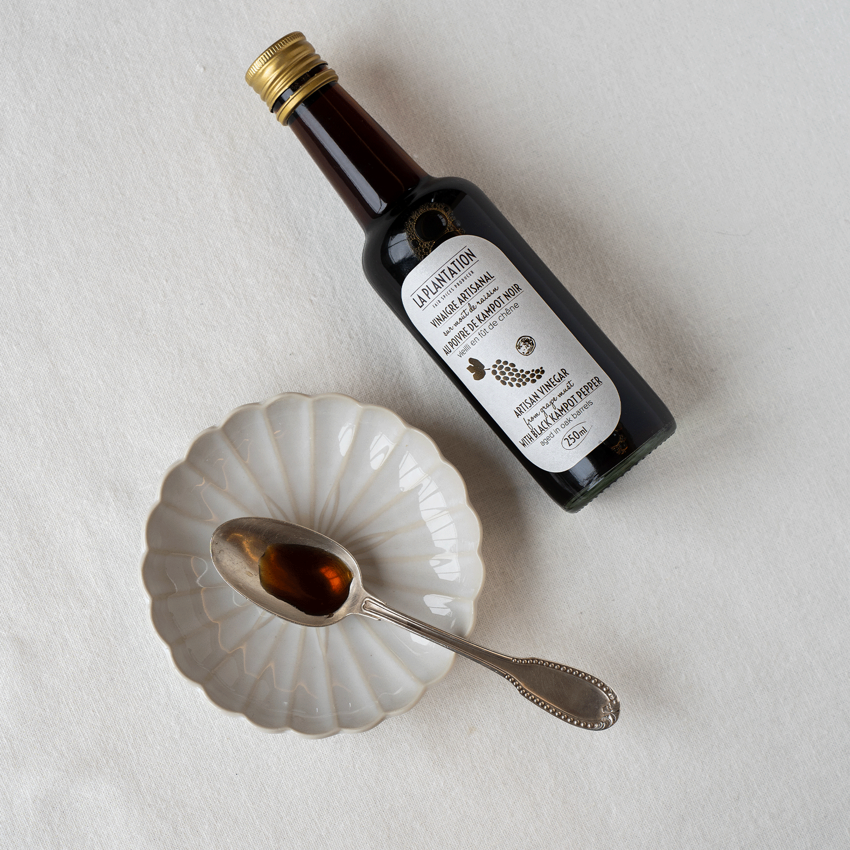 bouteille de vinaigre au poivre et cuillère dans une assiette