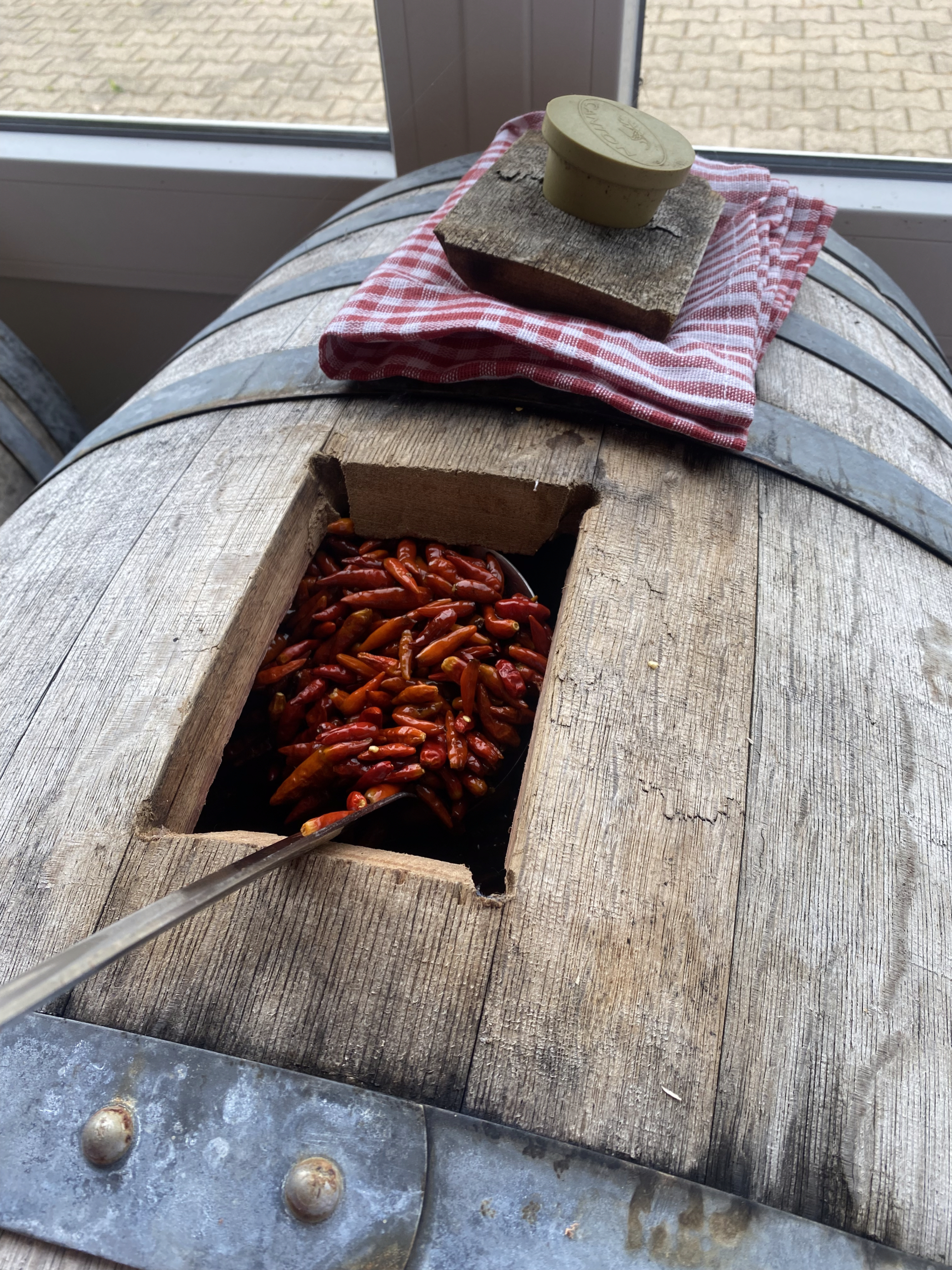 piments ajoutés dans un tonneau de vinaigre