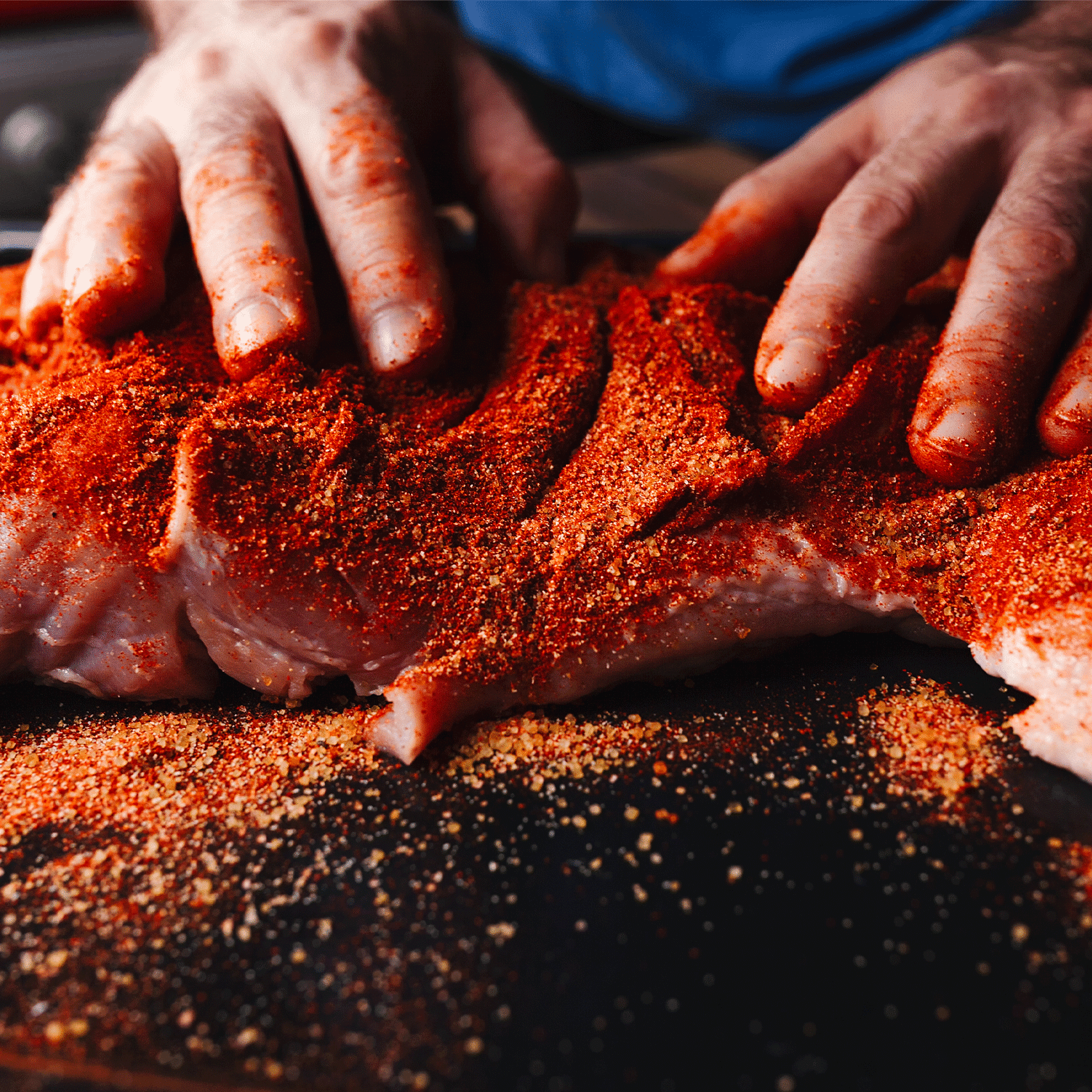 personne en train de badigeonnée une pièce de viande