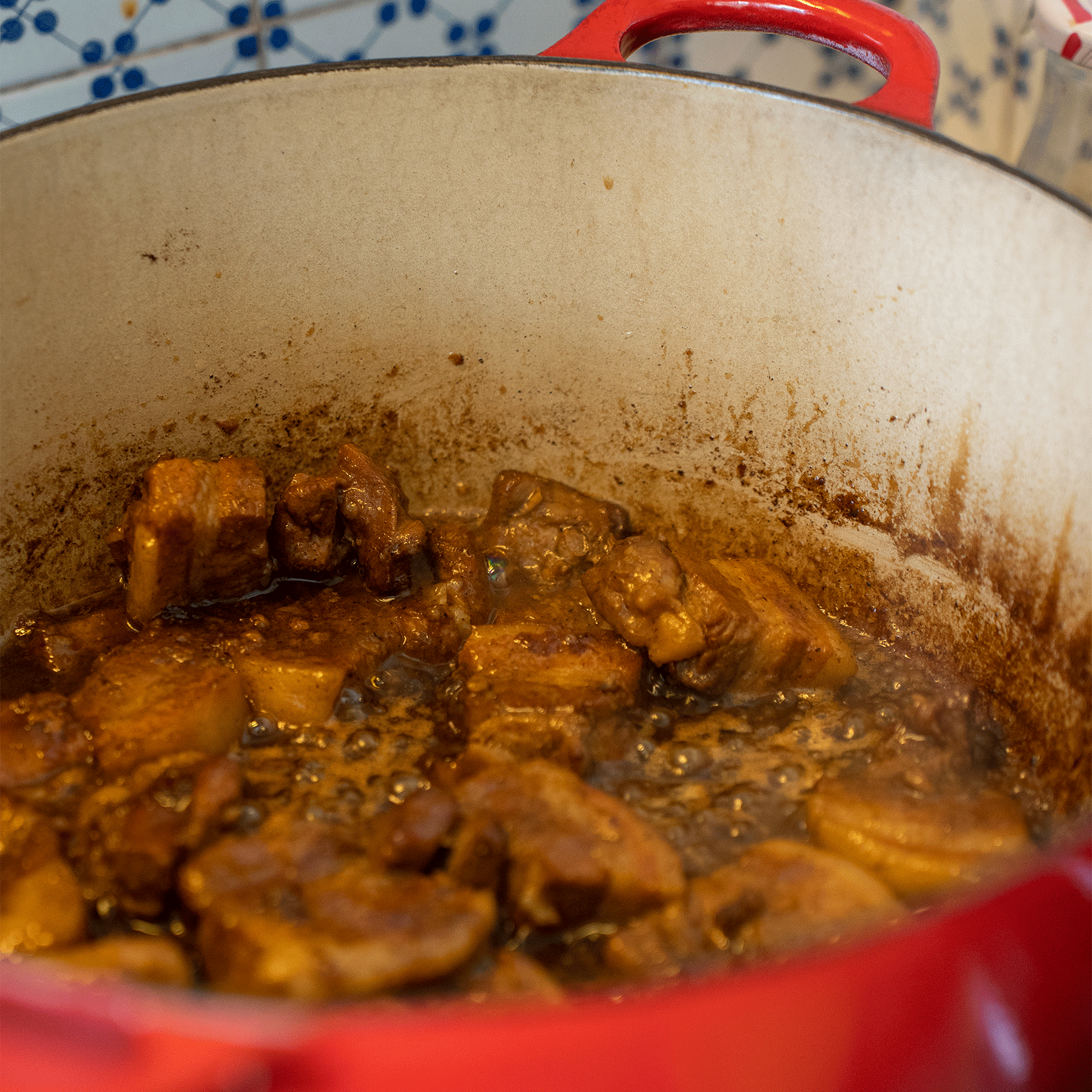 intérieur d'un plat en fonte avec sauce en train de mijoter